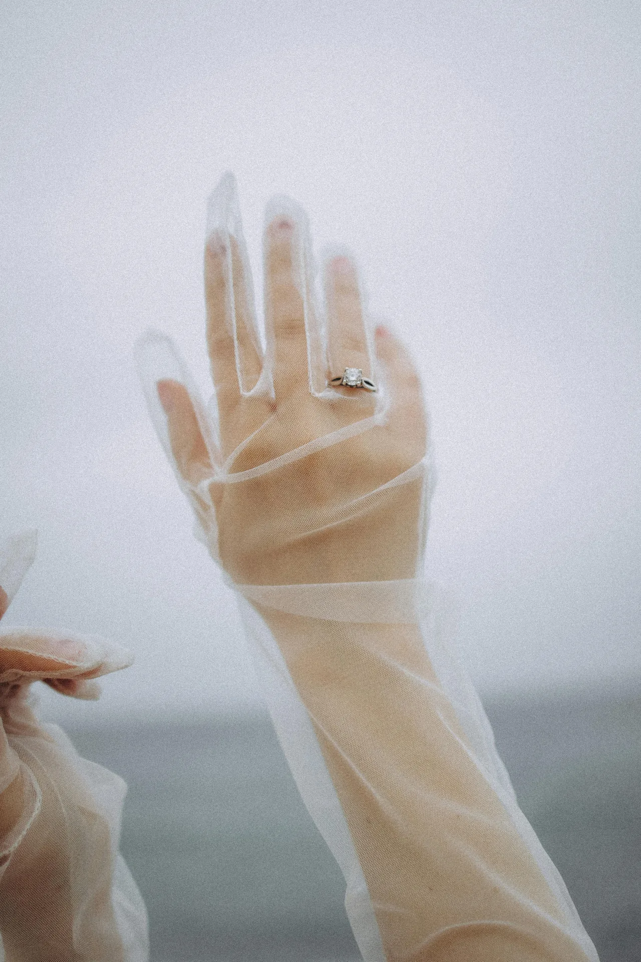 Hand in tulle glove with diamond ring